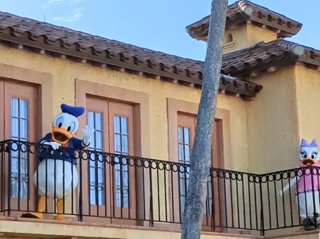 Donald and Daisy wave from a balcony near Hollywood Studios' entrance