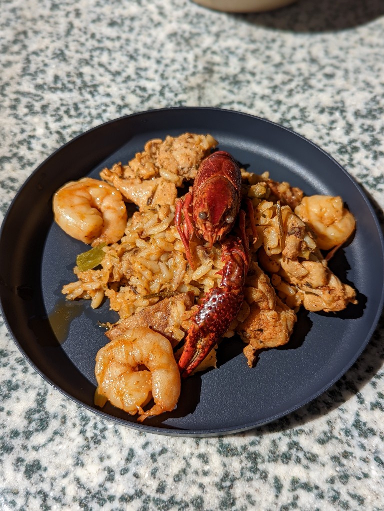 Chicken and shrimp jambalaya beautifully plated with a crawfish perched on top