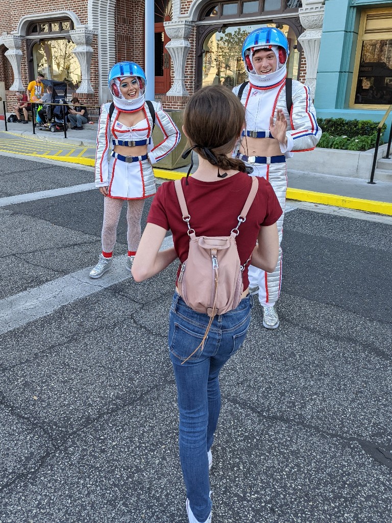 A girl chats with Universal Mardi Gras parade performers during the day