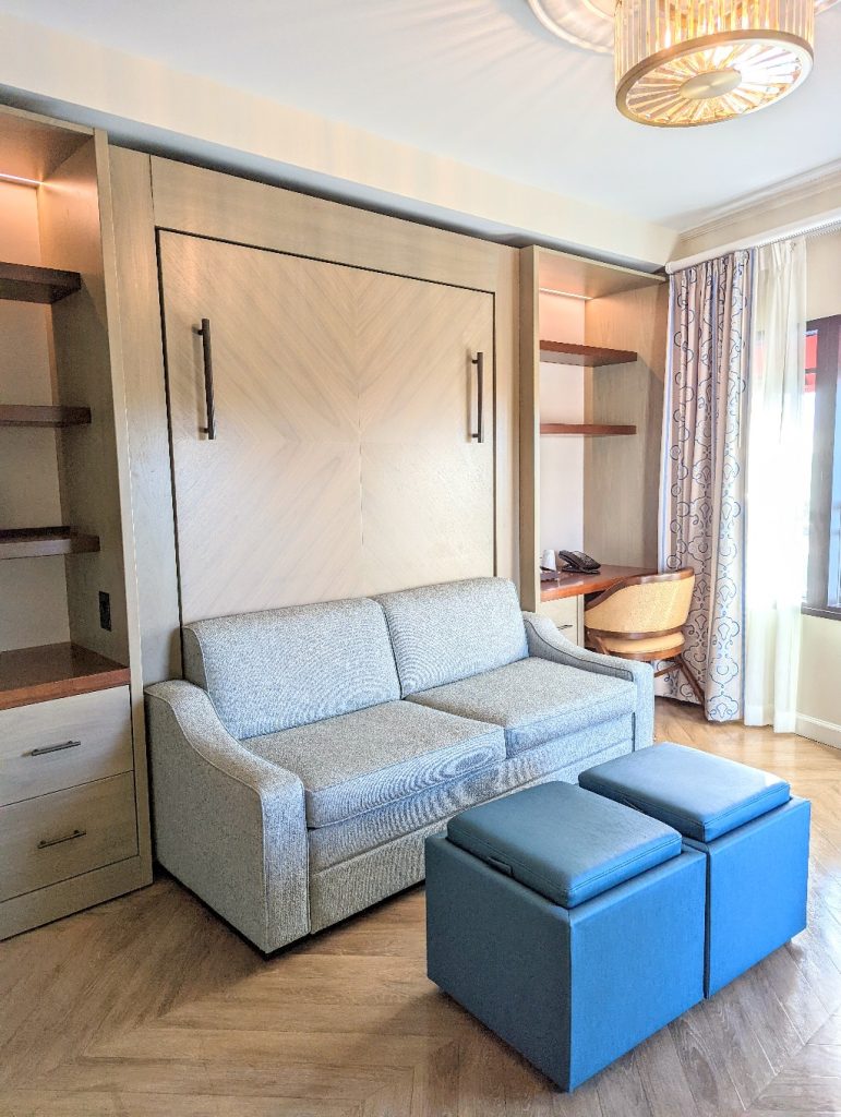 A couch with built in cabinets on either side is the focal point of the Riviera Tower Studio when first entering