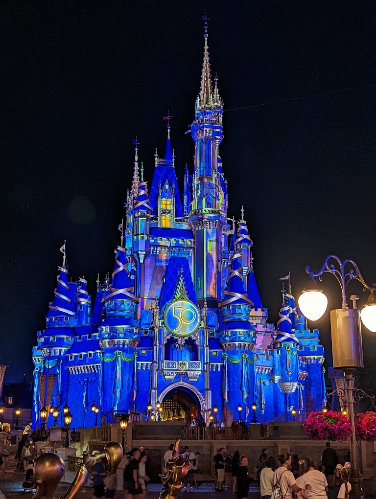Cinderella Castle with a small crowd in front during Extended Evening Theme Park Hours
