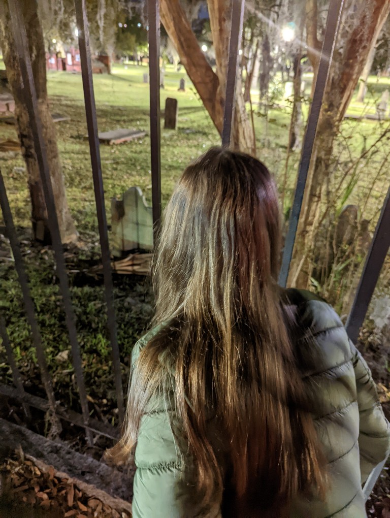 Girl peers into Colonial Park Cemetery in Savannah on a ghost tour