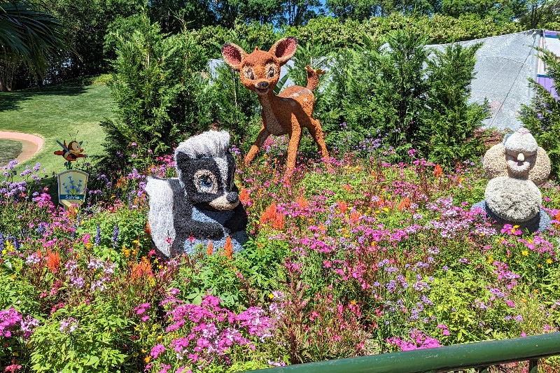 Bambi, Thumper, and Flower distract guests from finding Spike near the butterfly house