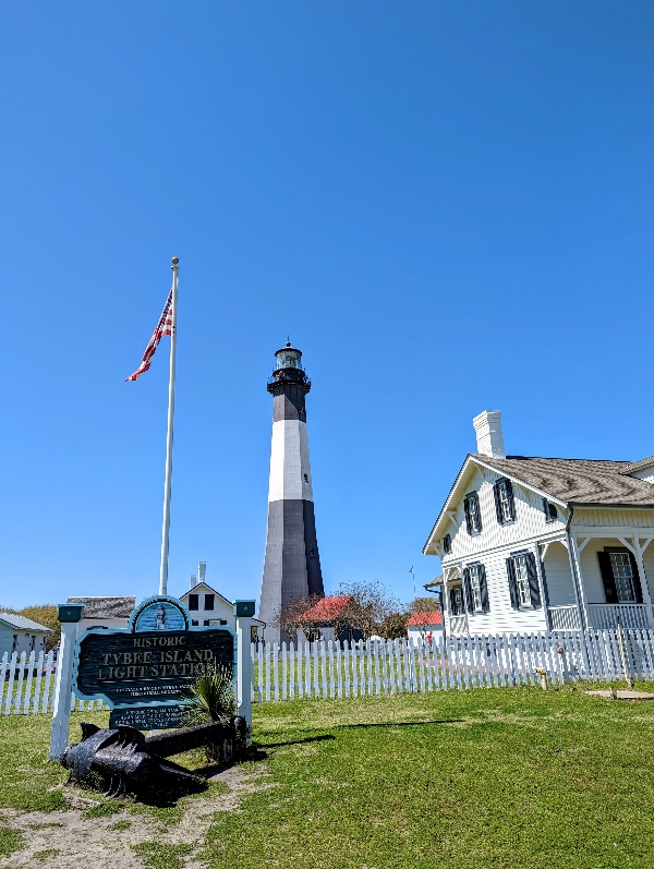 Tybee Island Light Station sign in front of keeper cottage and Tybee Island Lighthouse