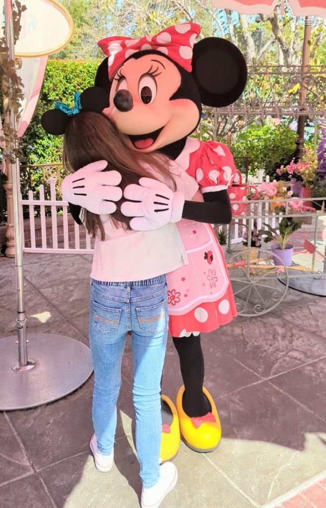 Minnie hugs Elizabeth when she enters Plaza Inn character breakfast at Disneyland