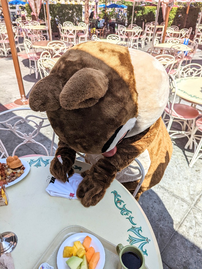 Dale signs our autograph pillowcase at Plaza Inn breakfast with Minnie and Friends