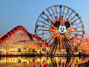 Mickey's Fun Wheel and Incredicoaster in the background lit up at night on Pixar Pier at Disney California Adventure
