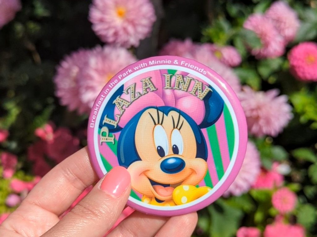 Souvenir Plaza Inn pin with Minnie Mouse image in front of pink flowers at Plaza Inn
