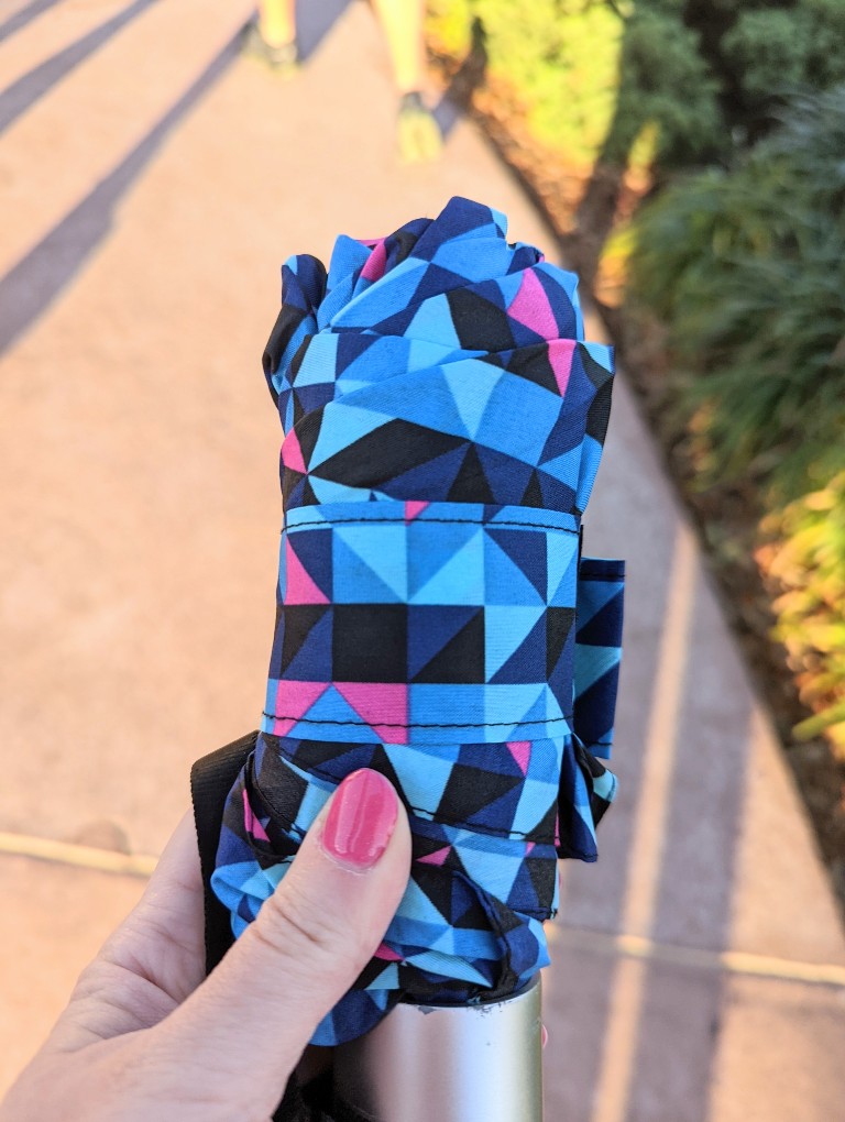 A geometric patterned umbrella is held out for security screening