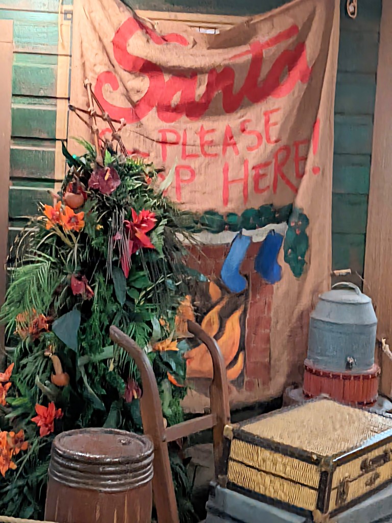 A "Christmas" tree made of palm fronds and tropical flowers and painted fireplace are just part of the decorations that transform Jingle Cruise at Mickey's Very Merry Christmas Party