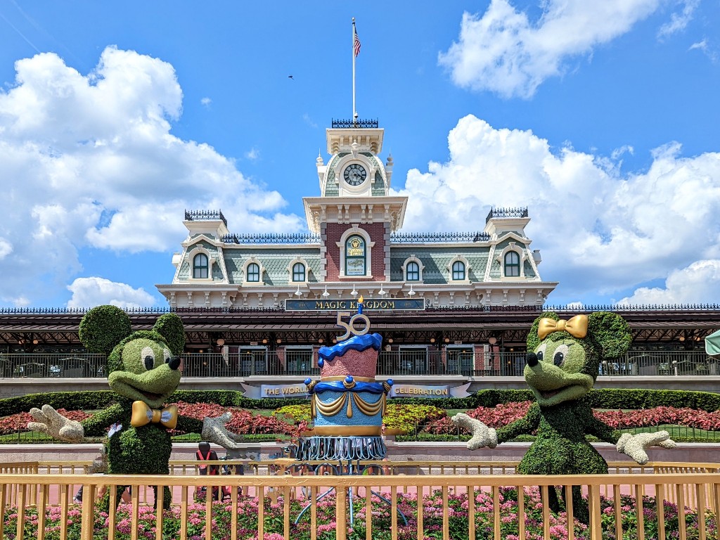 Mickey and Minnie topiary under a blue sky at the entrance of Magic Kingdom
