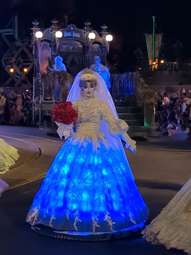 Constance from the Haunted Mansion eerily glows blue on Main Street during Boo To You