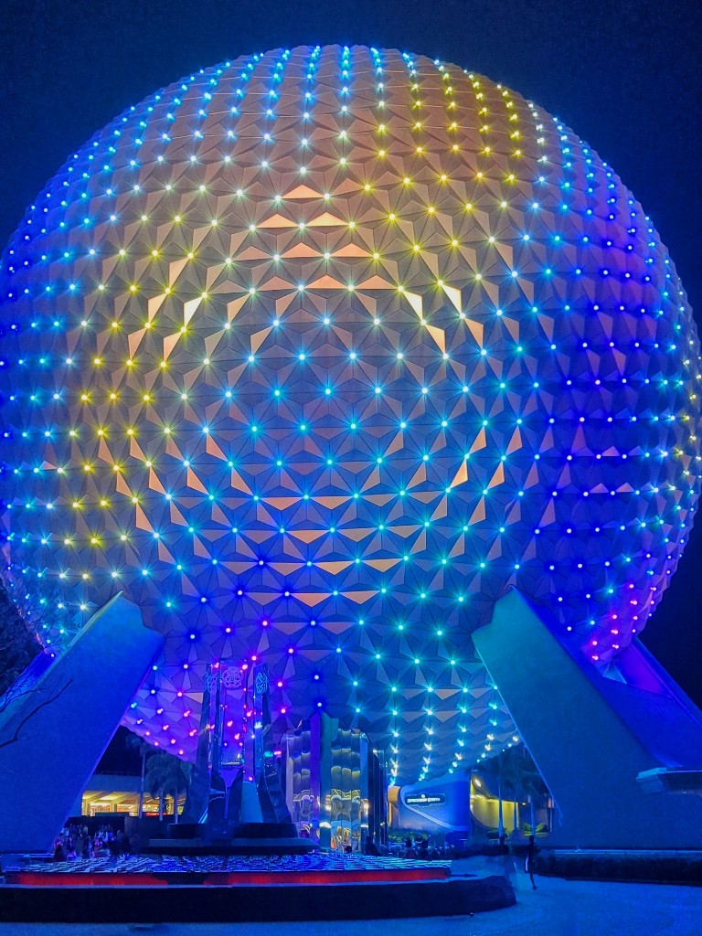 Spaceship Earth lit up in blues and yellow