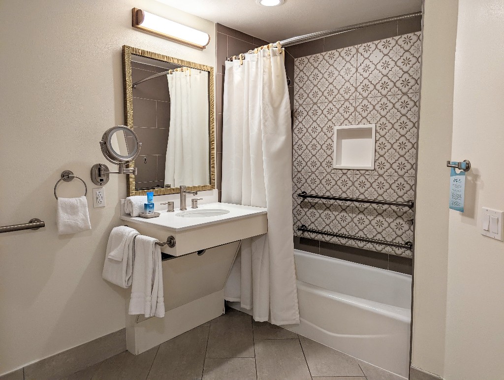 Cream and neutral mosaic tiles surround a bathtub in our Saratoga Springs accessible 1 bedroom villa