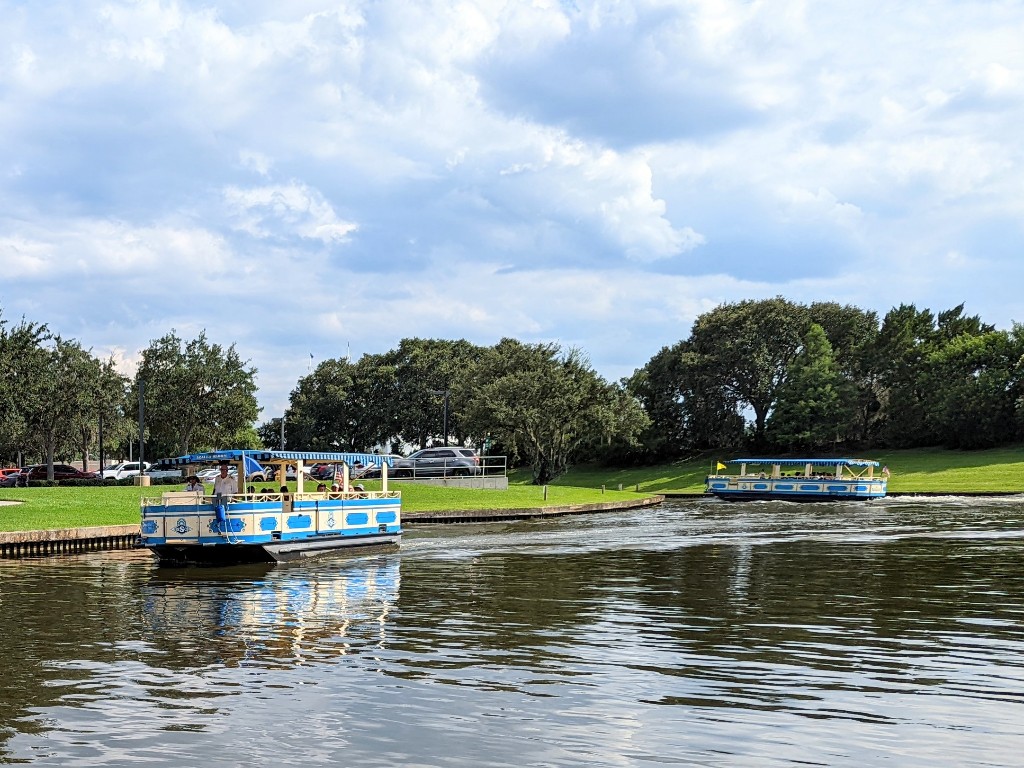 Boats glide across the water taking guests from Saratoga Springs to Disney Springs