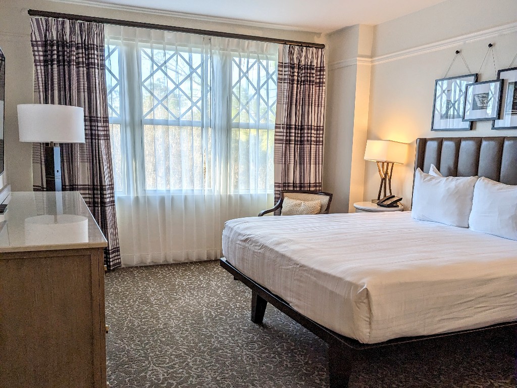 A platform bed with cute Disney themed decor above the headboard, dresser, and comfortable chair make the Saratoga Springs bedroom a relaxing place to rest