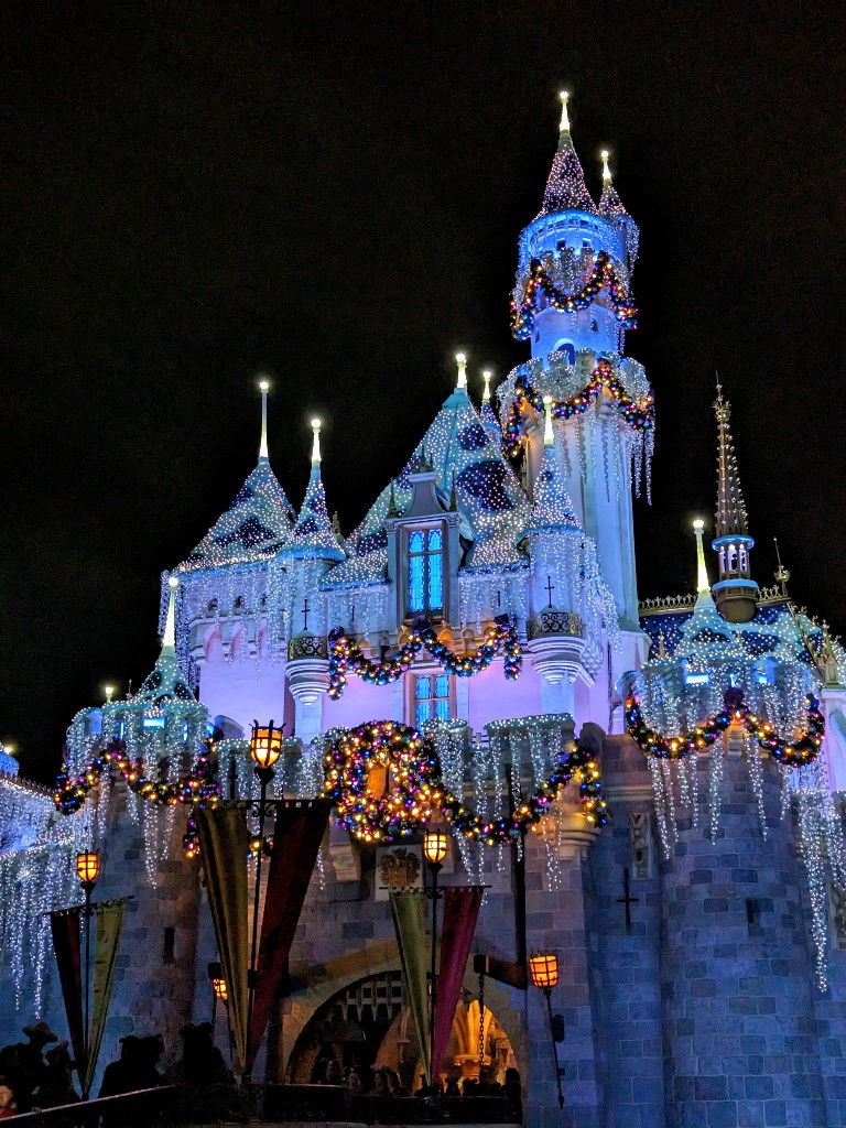 Sleeping Beauty Castle with snow capped turrets, sparkling icicles, and colorful garland