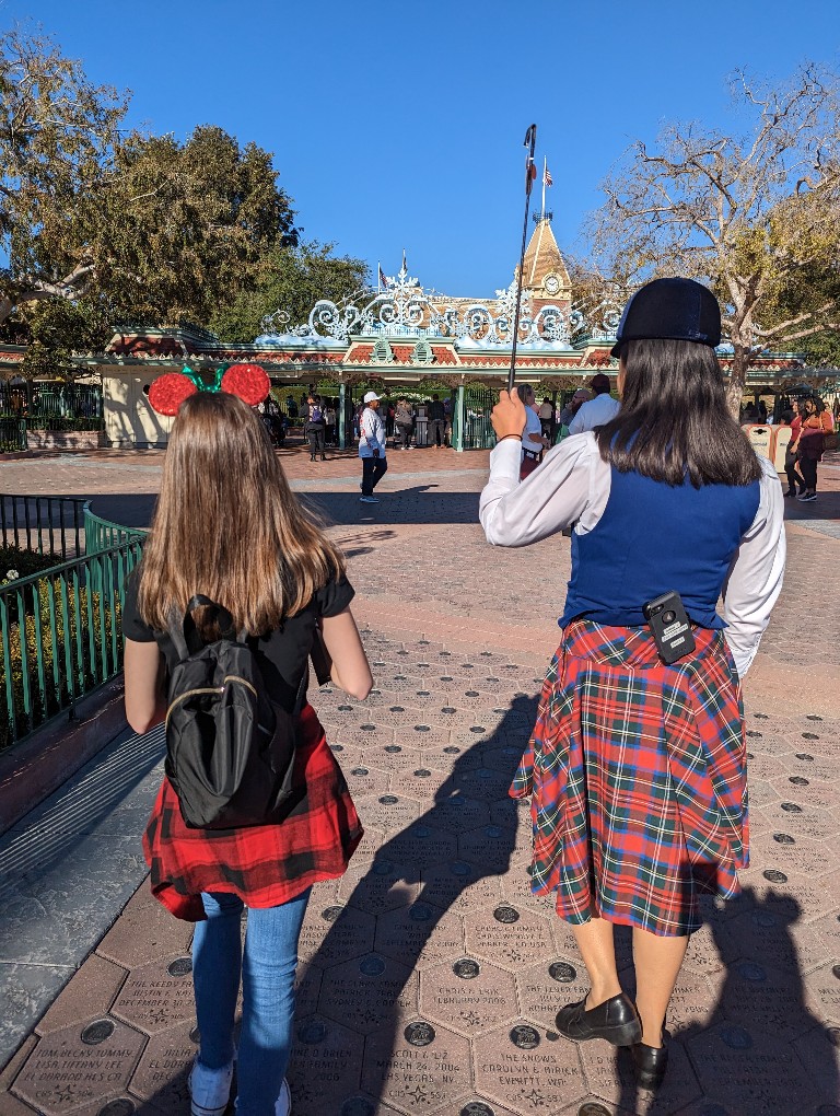 A Disneyland tour guide leads a group from Disney California Adventure to Disneyland