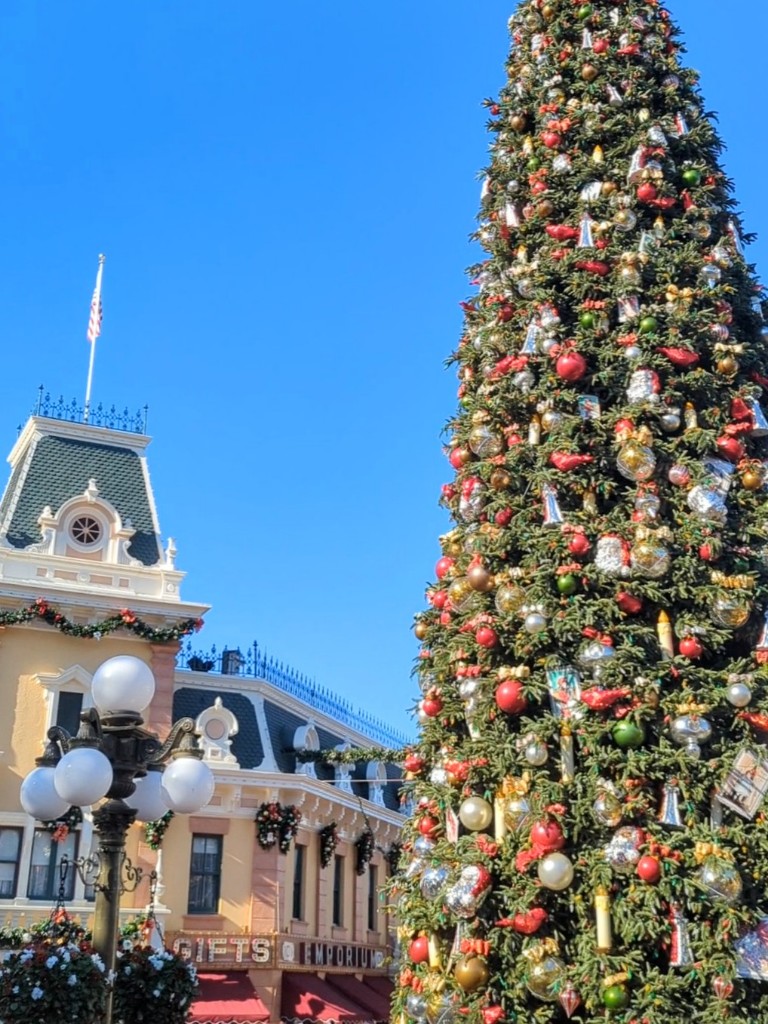 A beautifully decorated Disneyland Christmas tree soars above Main Street USA