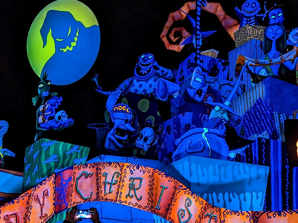 Oogie Boogie's shadow over the moon greets guests loading Haunted Mansion Holiday