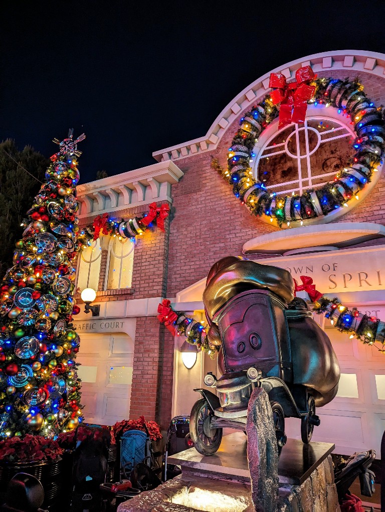 Radiator Springs bathed in colorful lights, hubcap ornaments, and air filter wreaths