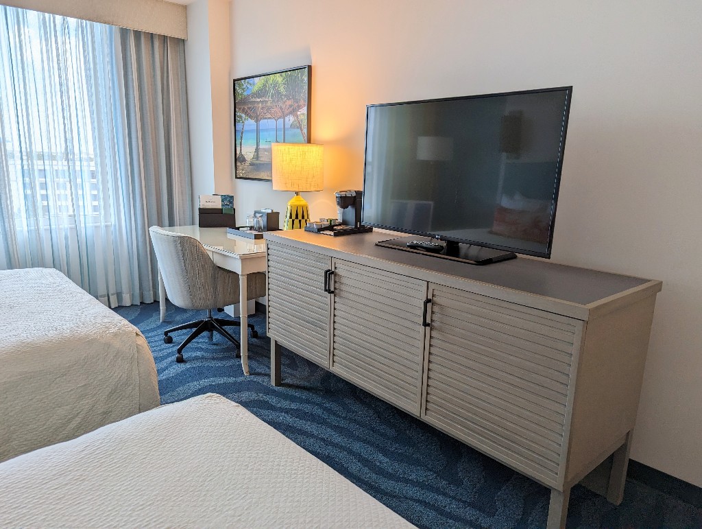 A framed tropical photo above the desk brings a bit of the islands into a Sapphire Falls 2 queen room