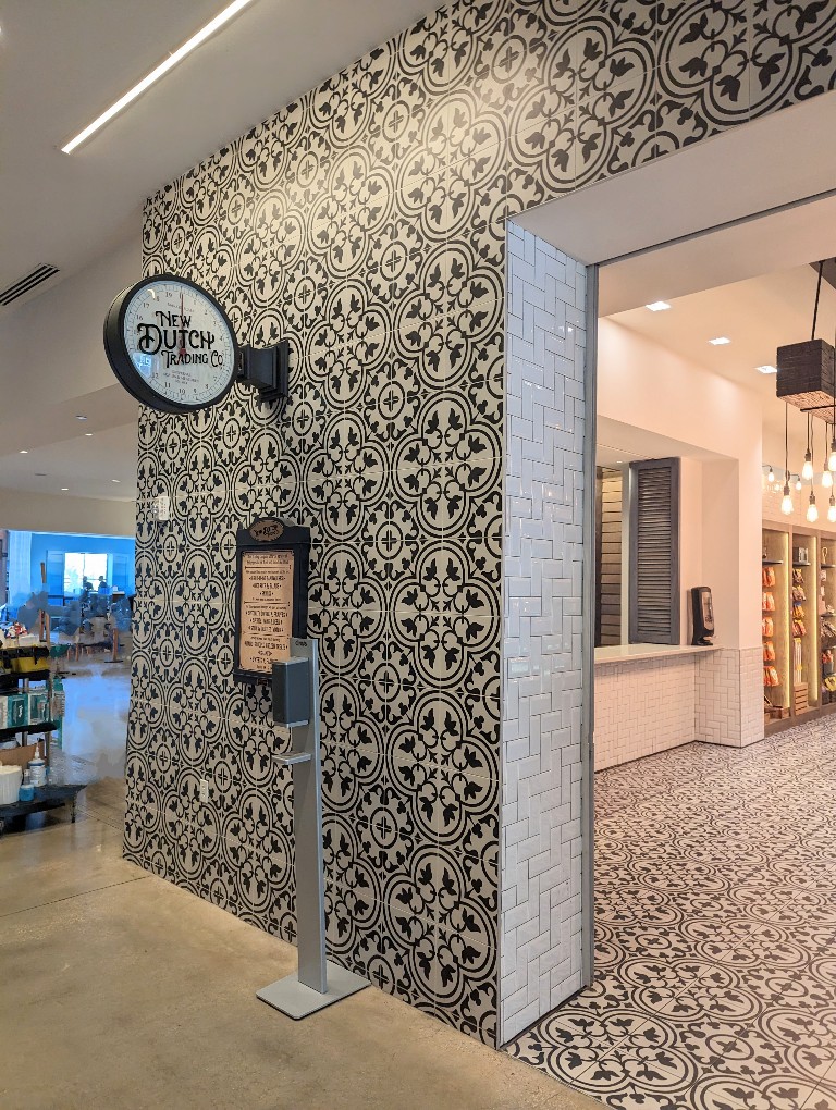 Ornate mosaic tile adorns the walls outside New Dutch Trading Co which has grab and go snack plus some hot foods.