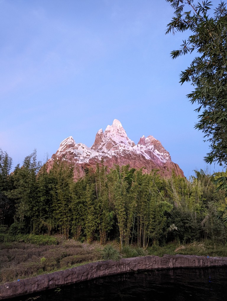 A periwinkle blue sky behind a sunset lit Expedition Everest at Disney's Animal Kingdom