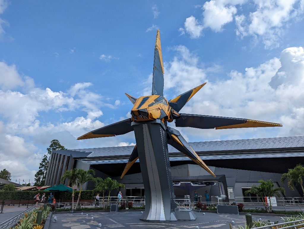 A bright yellow Nova Corp Starblaster hovers in front of Guardians of the Galaxy: Cosmic Rewind 