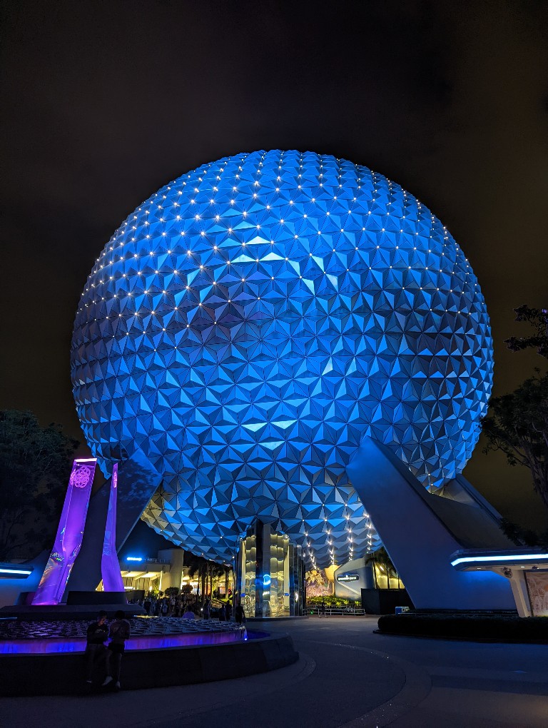 Spaceship Earth illuminated in soft blue during nighttime at Epcot