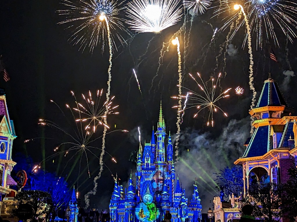 Fireworks explode over an illuminated Cinderella Castle and Main Street at Magic Kingdom