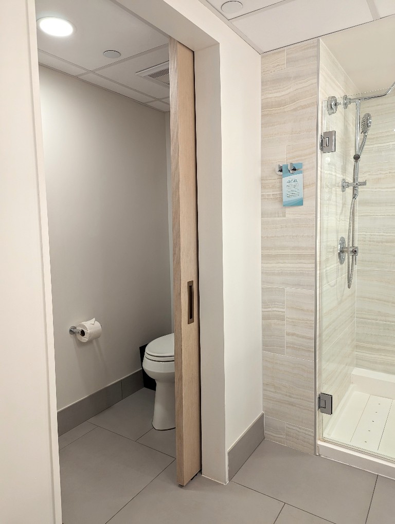 A pocket door separates the toilet area from the shower and sinks in Disney's Contemporary Resort Garden Wing rooms