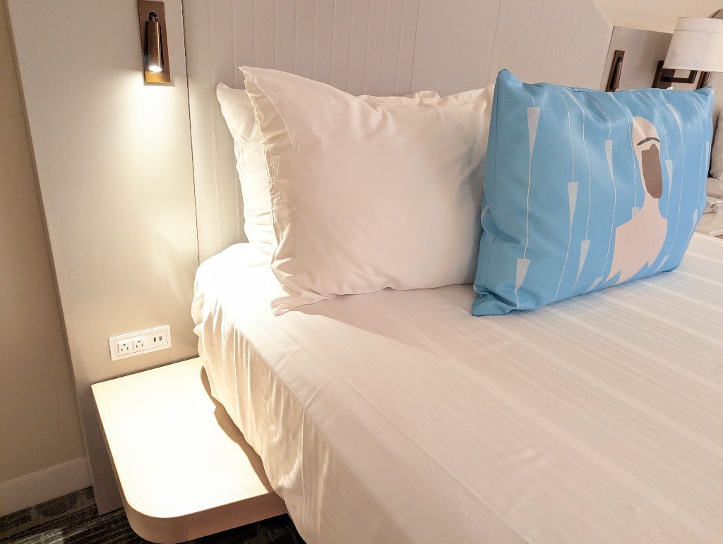 A small built-in side table with several plugs on the outside edge of Contemporary Resort Garden Wing bed