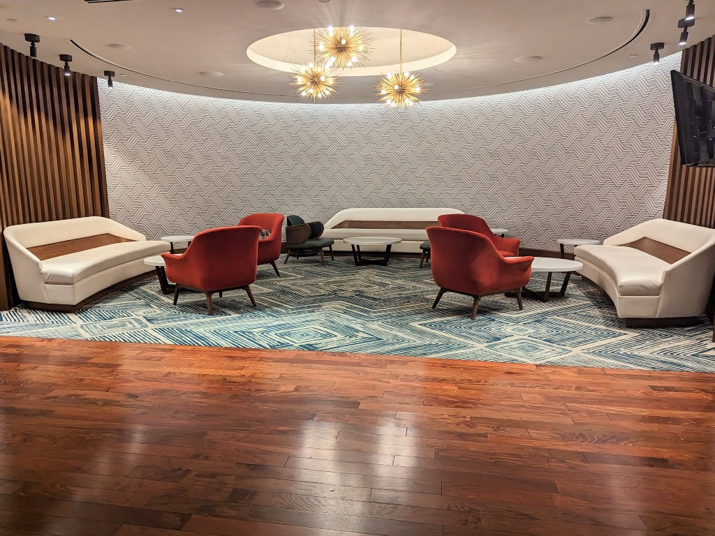 Mid-century modern couches, chairs, and light fixture in Steakhouse 71's cool waiting area.