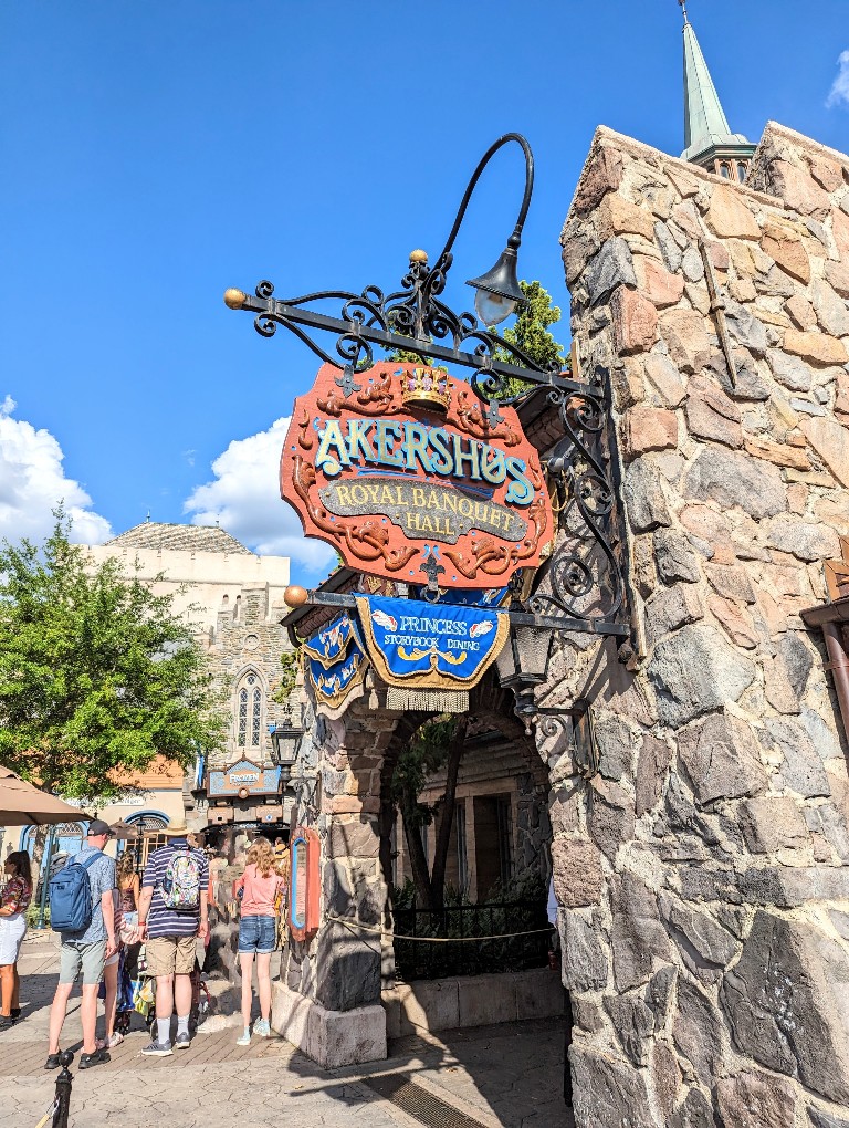 Blue skies frame the Akershus Royal Banquet Hall sign in front of Frozen Ever After at Epcot