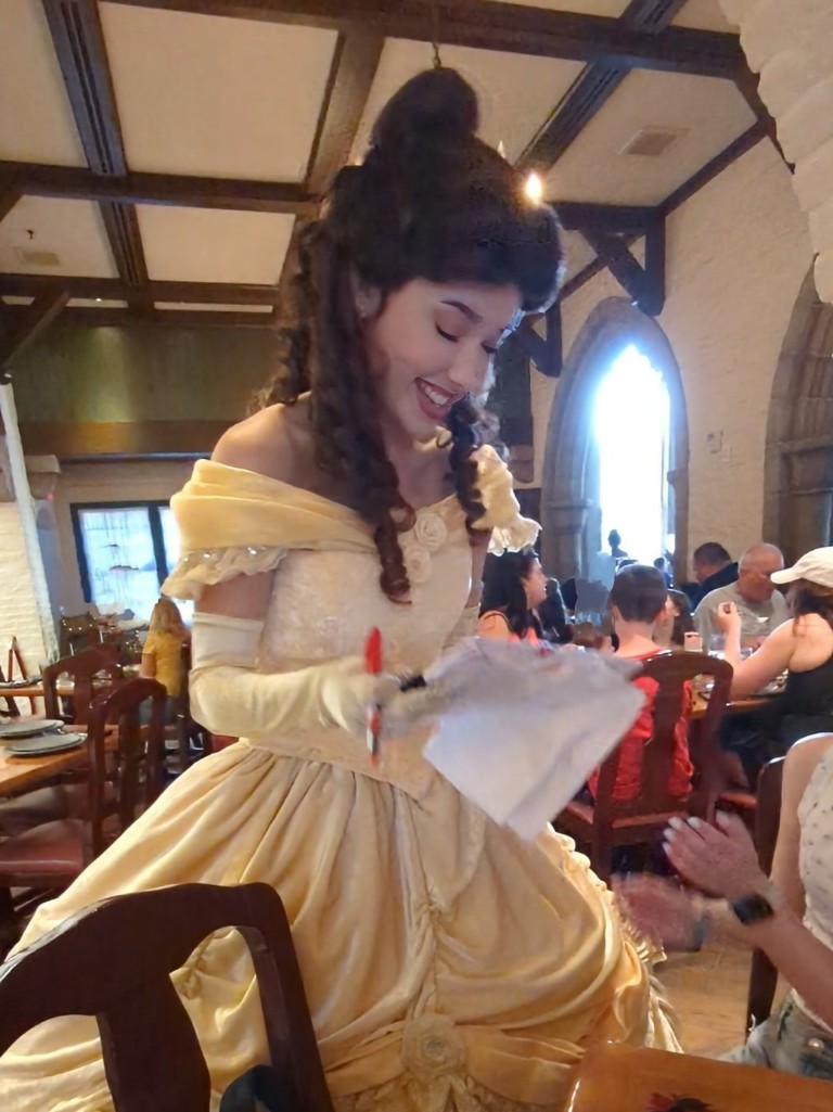 Belle smiles as she signs our DIY autograph pillowcase at Akershus