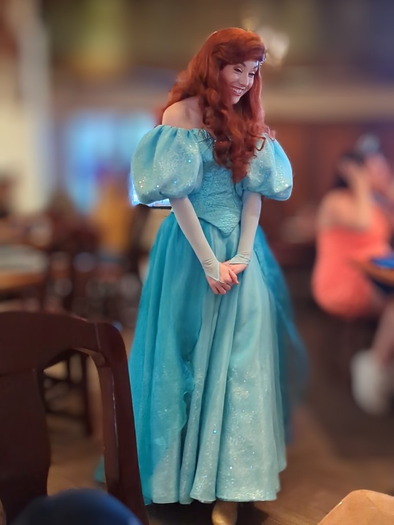 A serene smile adorns Ariel's face as she seems to float through Akershus in her gorgeous teal gown