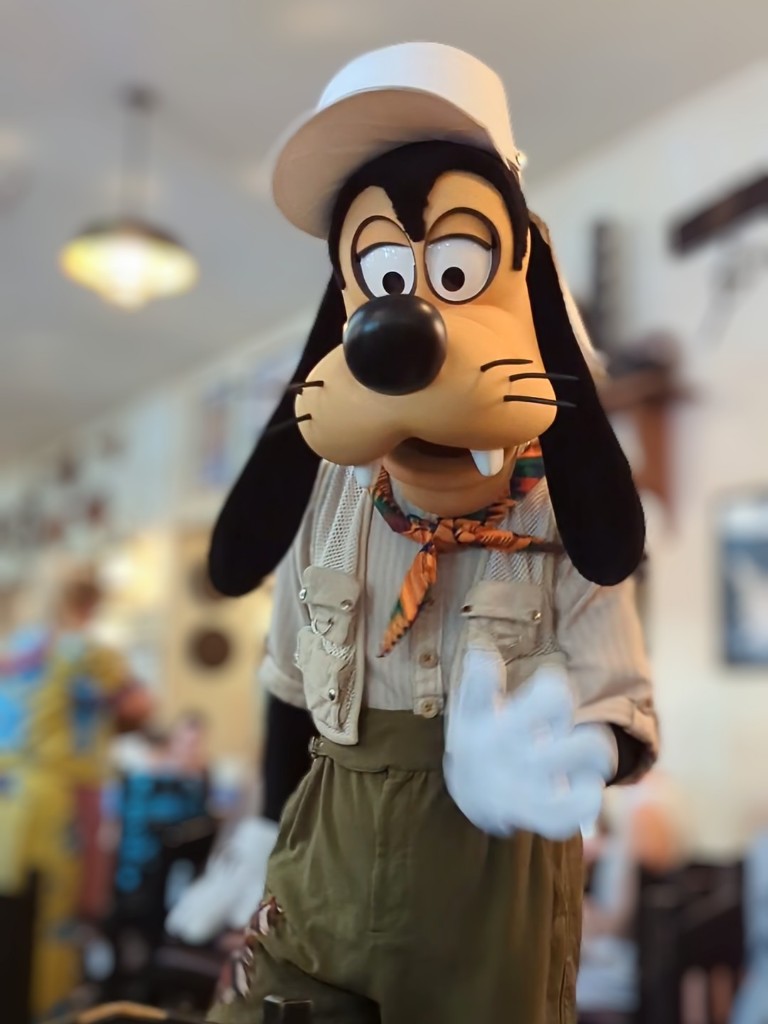 Goofy reaches out to offer to dance with us at Tusker House