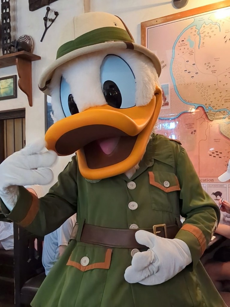 Donald Duck uses his hands to describe the hard work he's been doing all day at Tusker House
