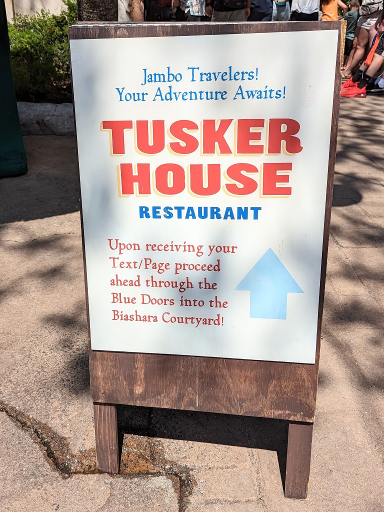 A sandwich board directs guests how to enter Tusker House once their table is ready