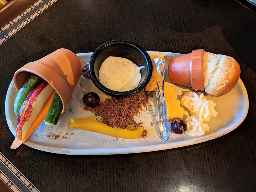 Kids appetizer plate with a roll, butter, veggies, ranch and cheese
