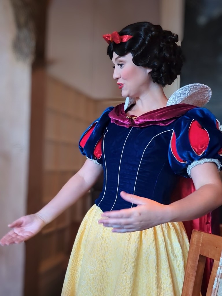 Snow White reaches out to offer a hug to guests at Story Book Dining