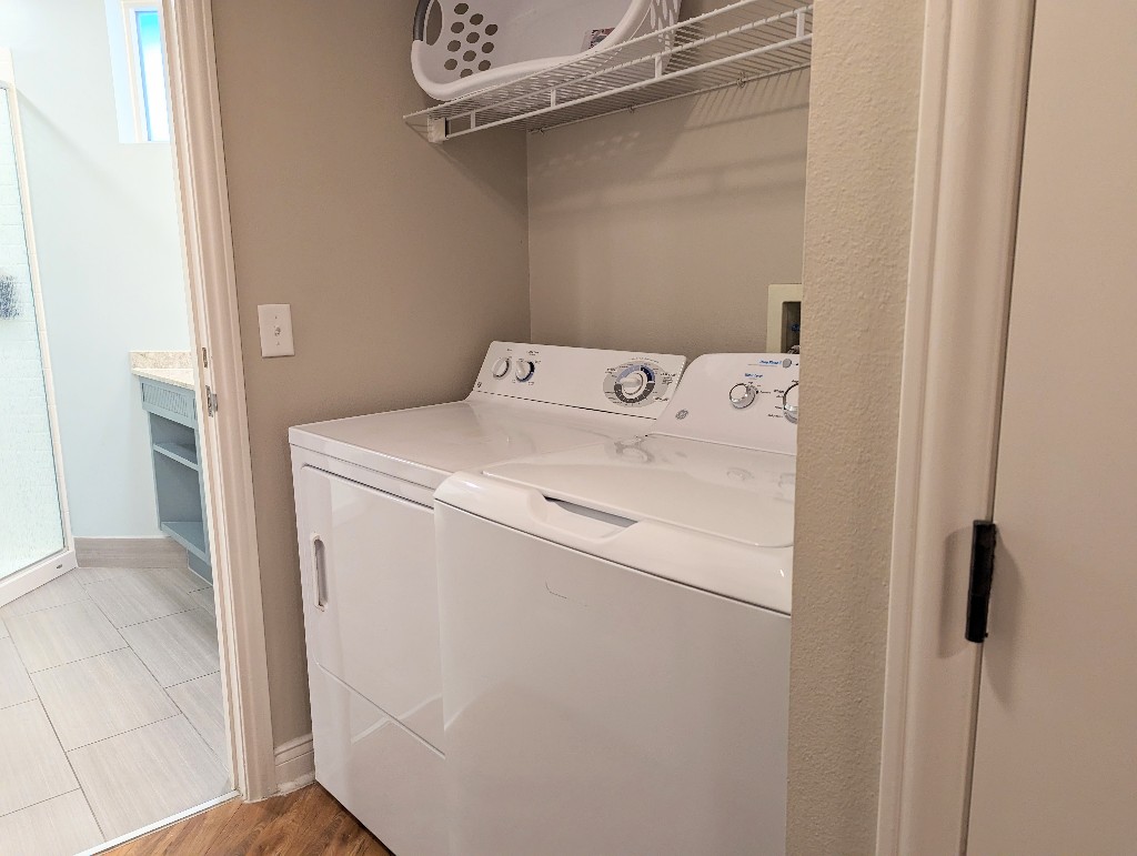 A full sized washer and dryer with shelving above in the hallway leading to the Old Key West 1 bedroom bathroom