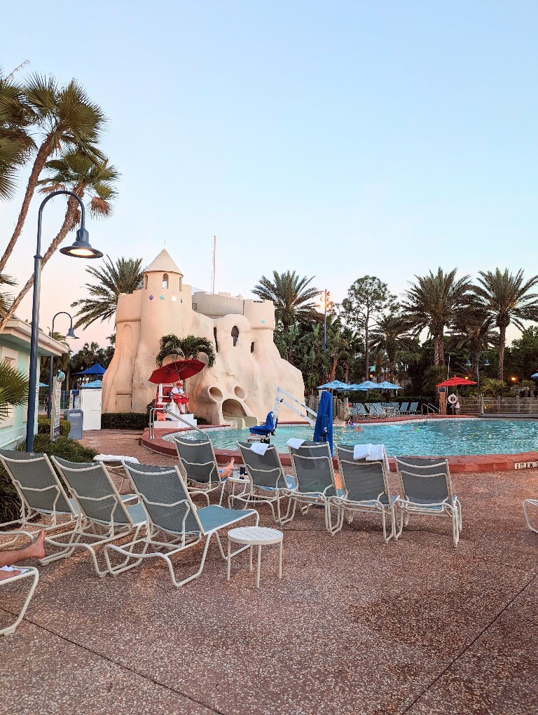 A giant sandcastle hides the fun water slide while palm trees and chairs surround Sandcastle Pool at Old Key West