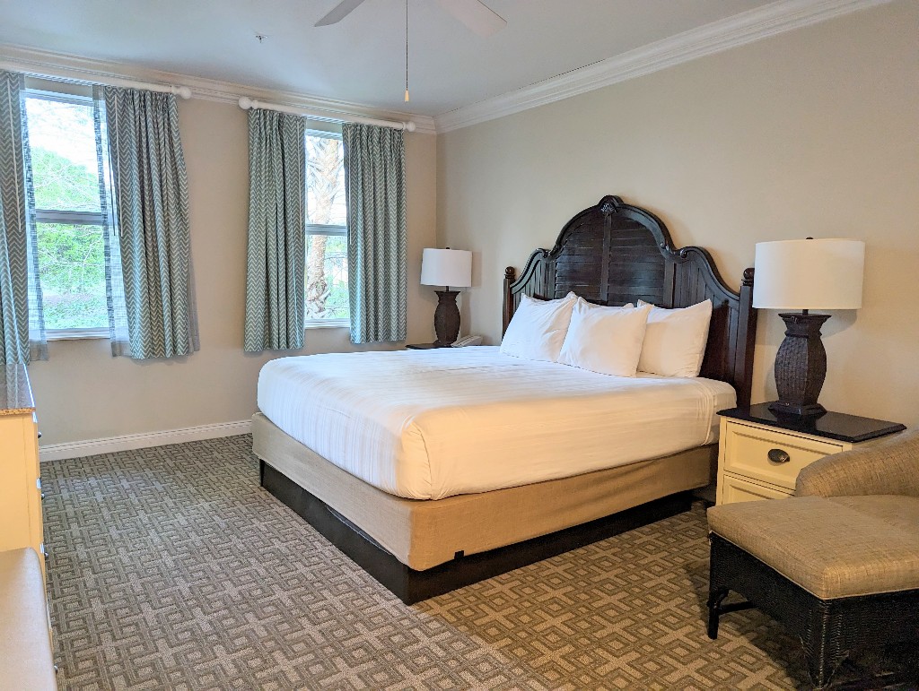 A dark wood headboard with bright white linens make for a comfortable, but unassuming bedroom in a Old Key West 1 bedroom villa