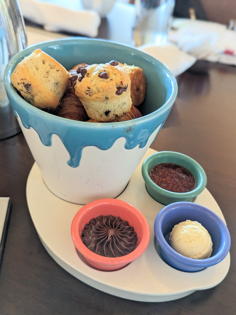 Chocolate chip muffins and butter croissants served with jam, butter, and hazelnut spread start your meal at Topolino's Terrace character breakfast