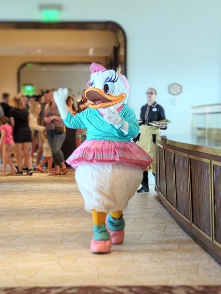 Daisy Duck sashays in a bright teal wrap top and bright pink tutu at Topolino's Terrace character breakfast