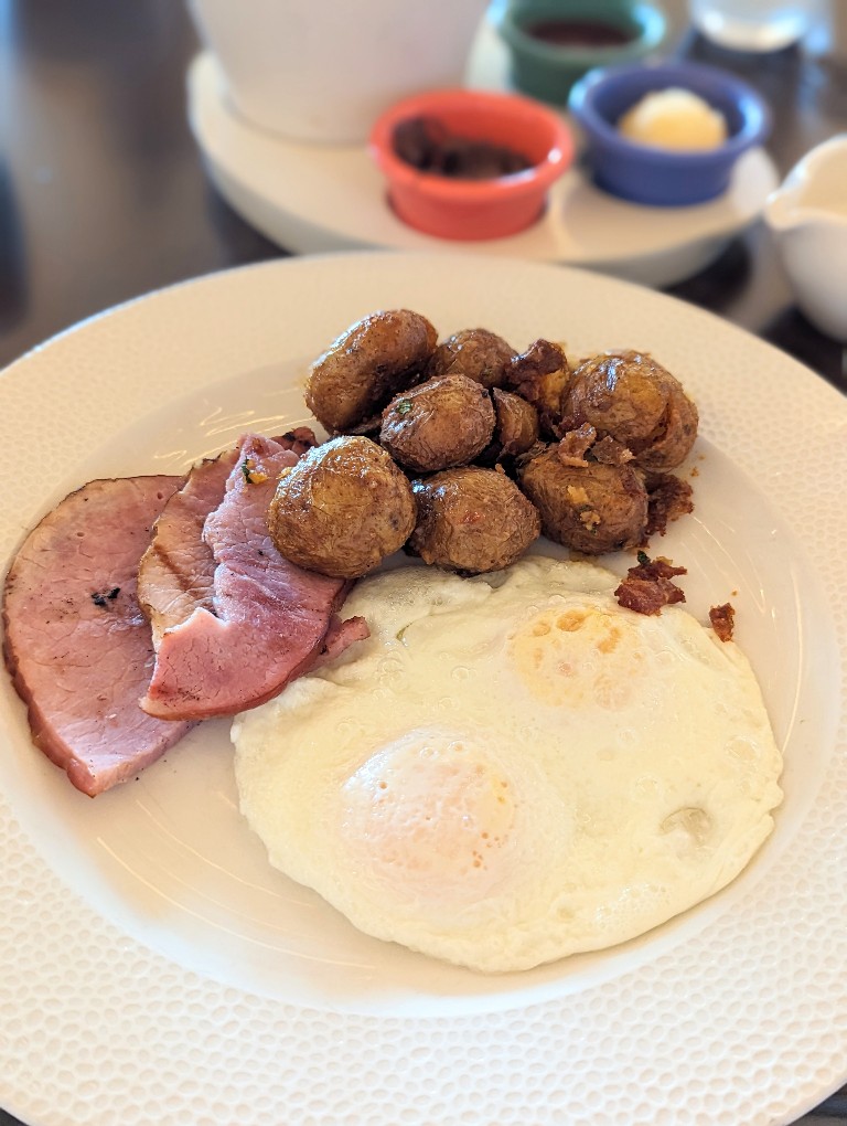 Crispy fingerling potatoes, two eggs, and a side of ham are a delicious way to start your day