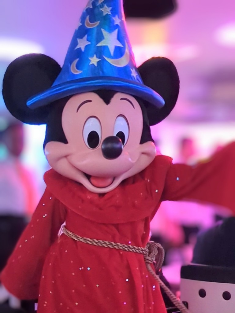 Sorcerer Mickey roams Animator's Palate in his signature blue hat with stars and sparkling red cloak on select Disney Cruises