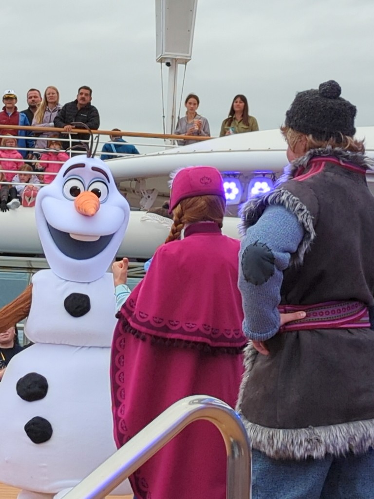 Olaf, Anna, and Kristoff look for Elsa during a Disney Wonder Alaska Cruise deck party, Freezing the Night Away